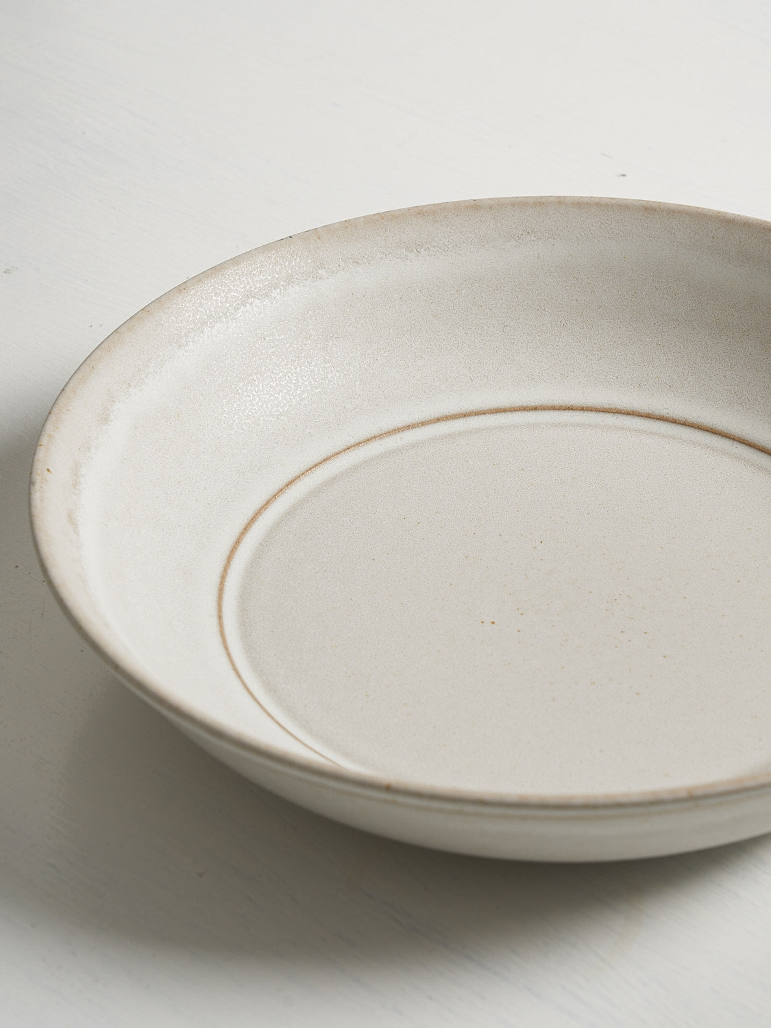 Detail of stoneware bowl lip and interior showcasing glaze texture