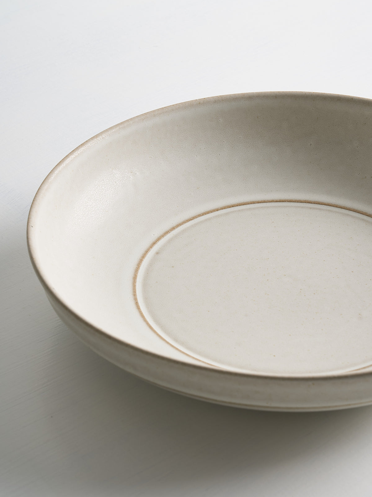White ceramic low serving bowl on a white background