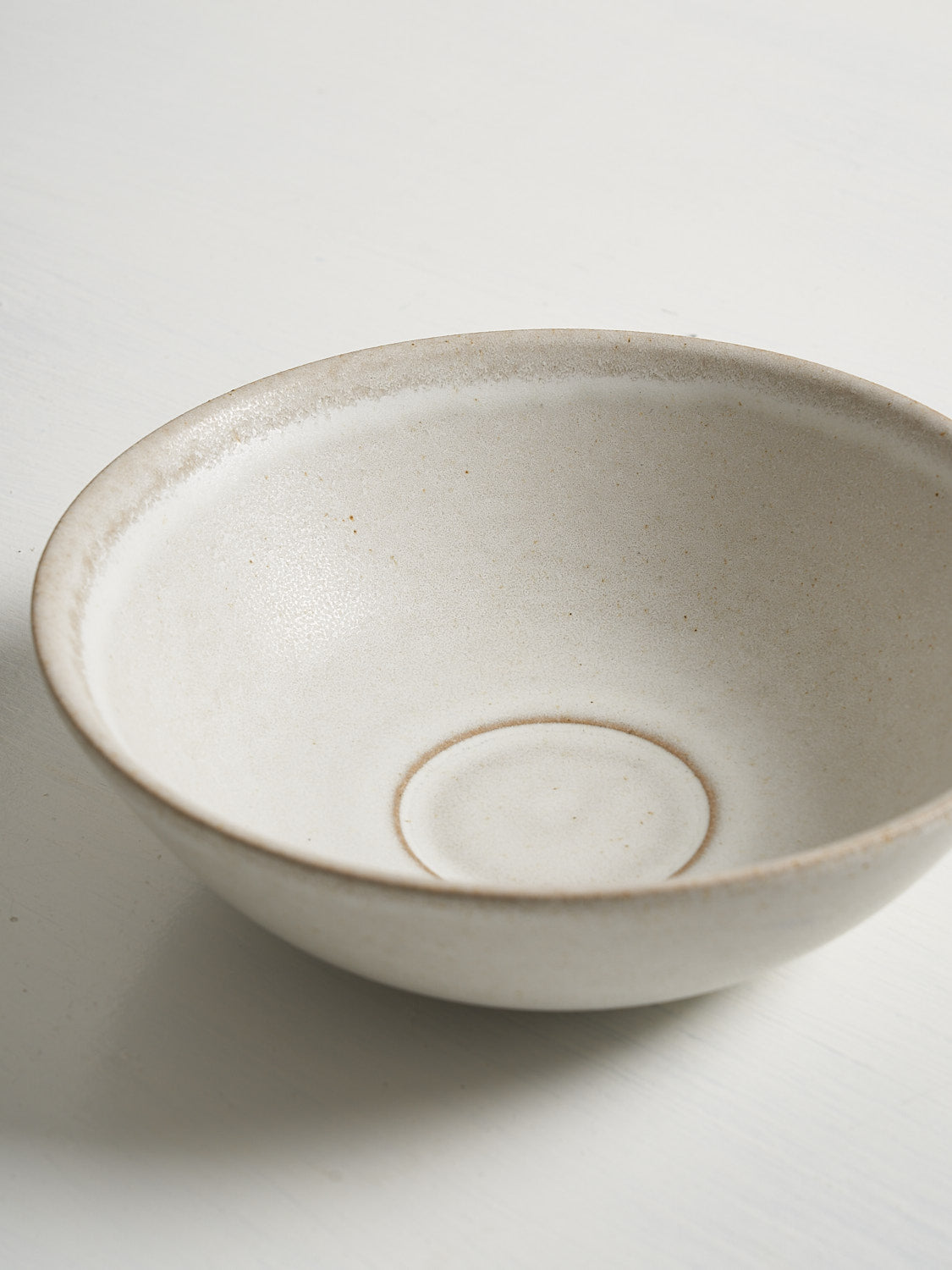 Close up of white ceramic soup or cereal bowl on white background.