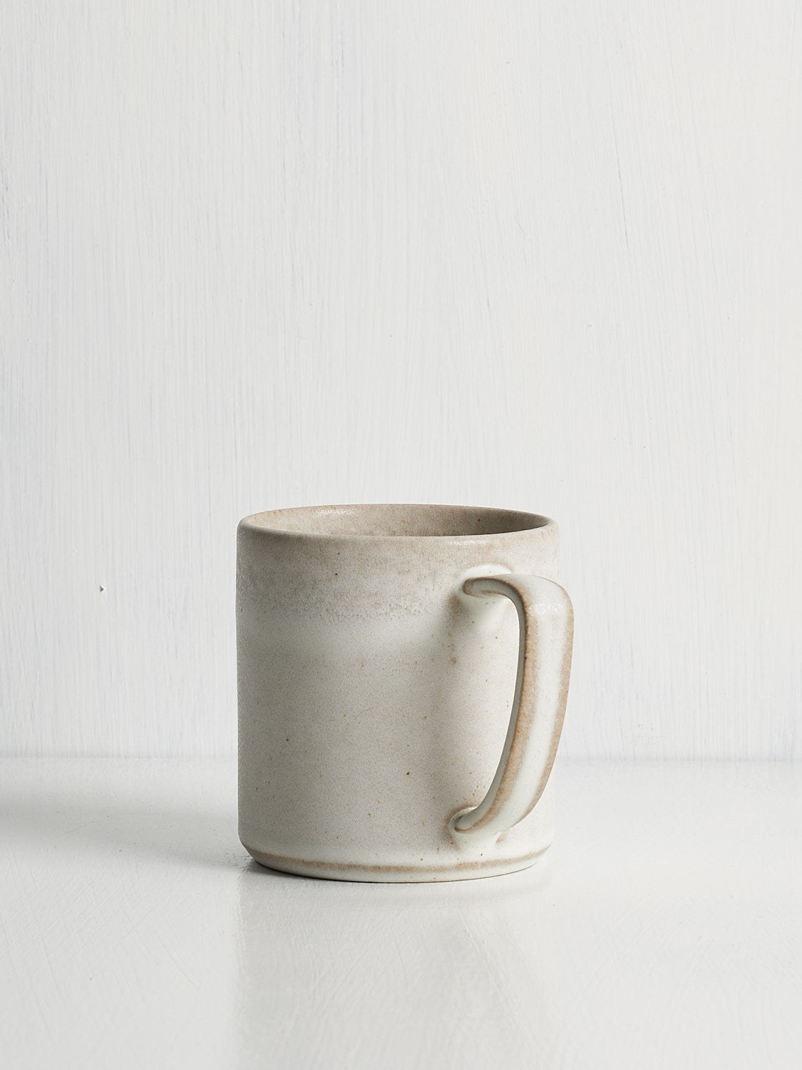 White stoneware mug with textured glaze on white backdrop
